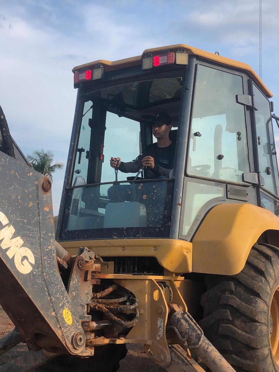 Aluno operando retroescavadeira durante o curso de Máquinas Pesadas