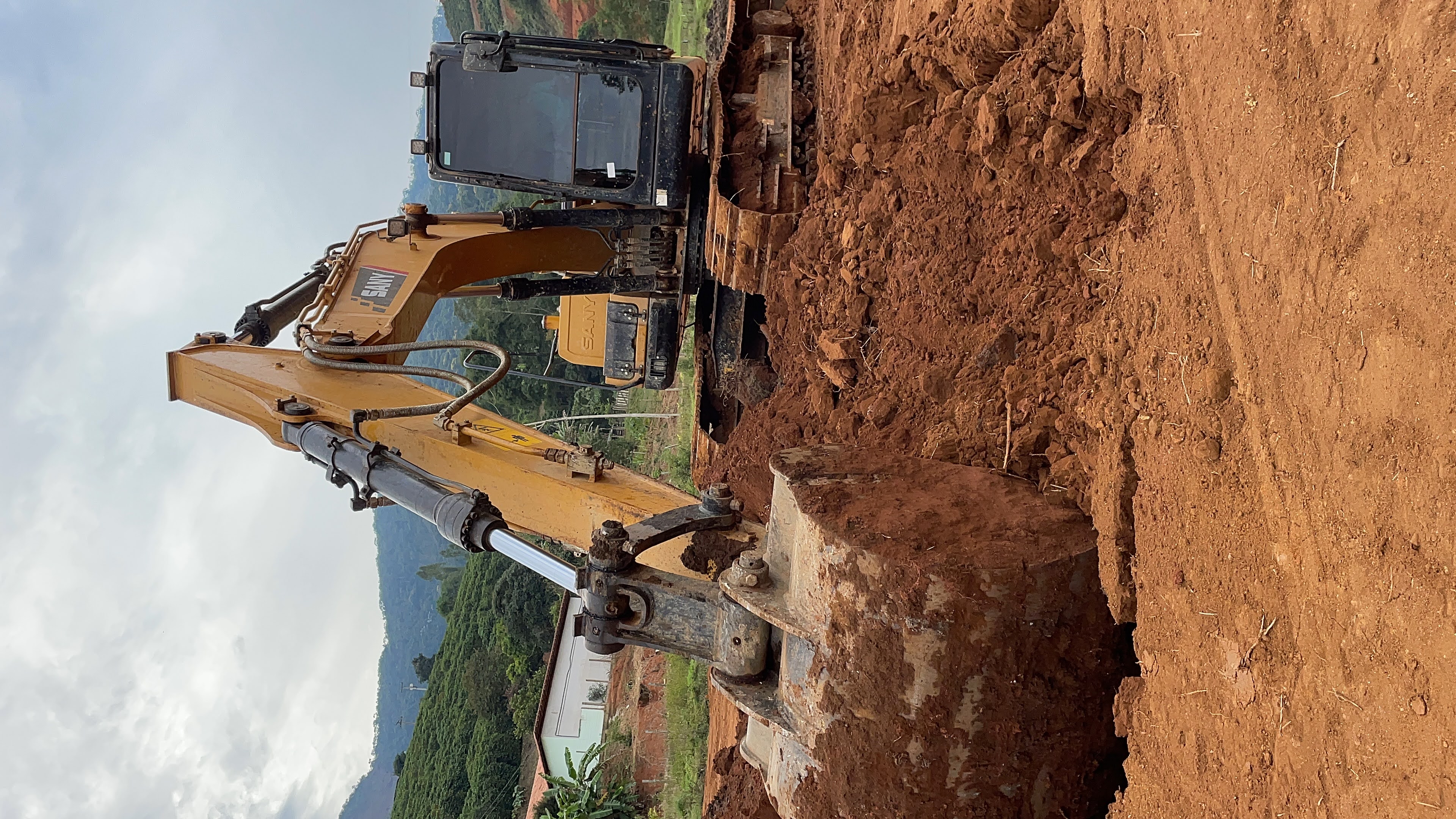 Instrutor da Target Agrotech mostrando os comandos da máquina pesada para um grupo de alunos em volta da cabine.